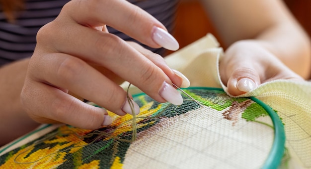 Mâini lucrând o broderie
